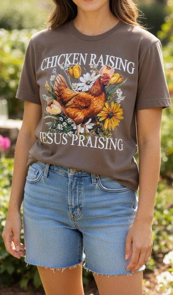 Woman wearing a brown t-shirt with a graphic design and text, standing outdoors.