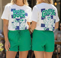 Two people wearing matching outfits with 'Duck Duck Goose' graphic t-shirts.